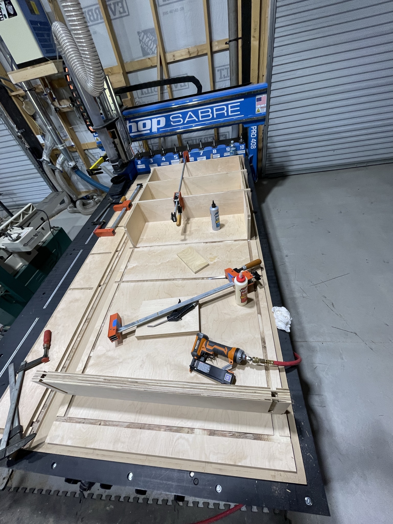 Photo of the assembly process of the custom-built sliding bookshelf by ArkWorks, designed as a room divider between the laundry area and living space